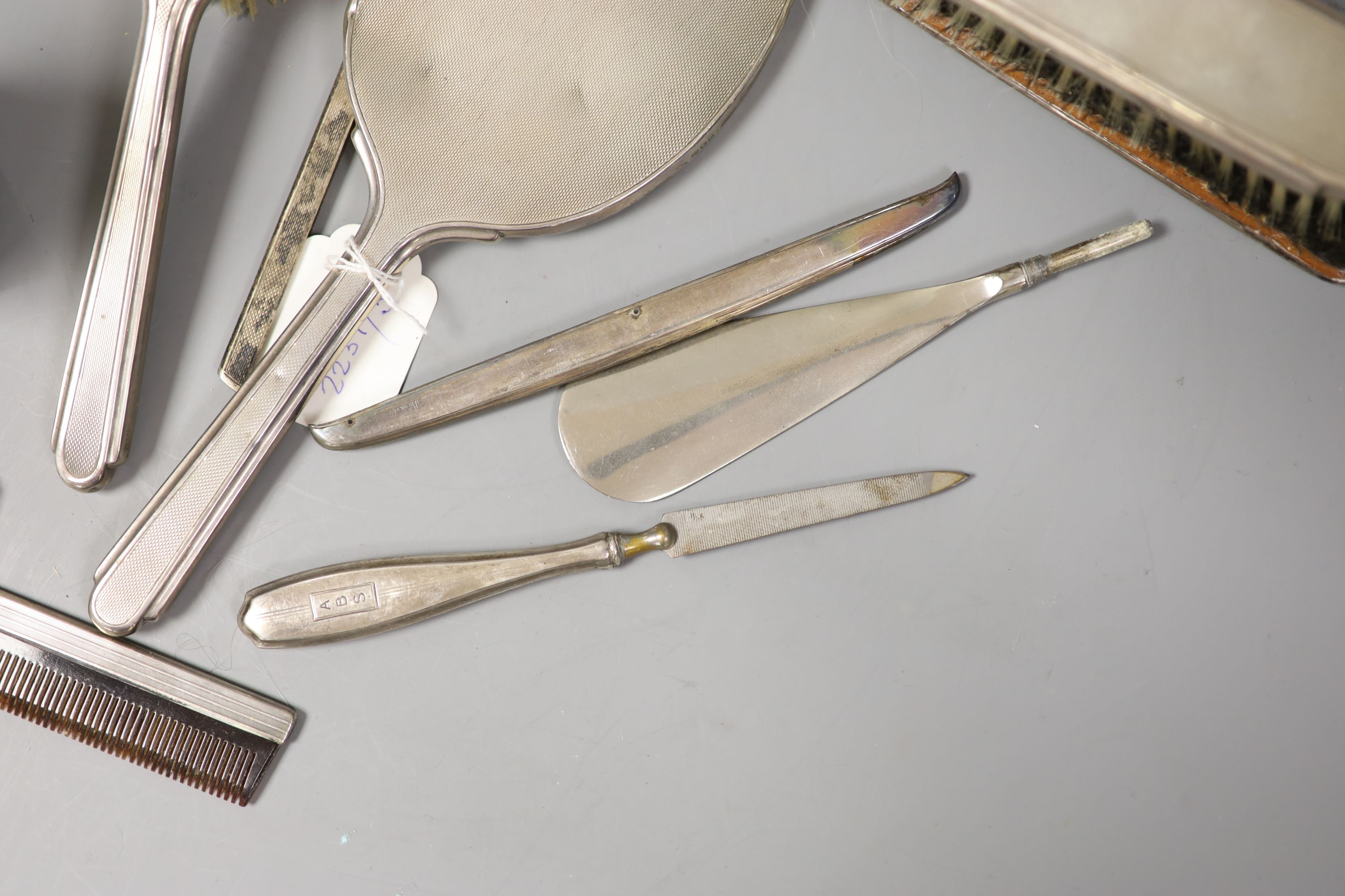 A 1940's silver mounted hand mirror and a group of other silver or sterling mounted brushes etc.